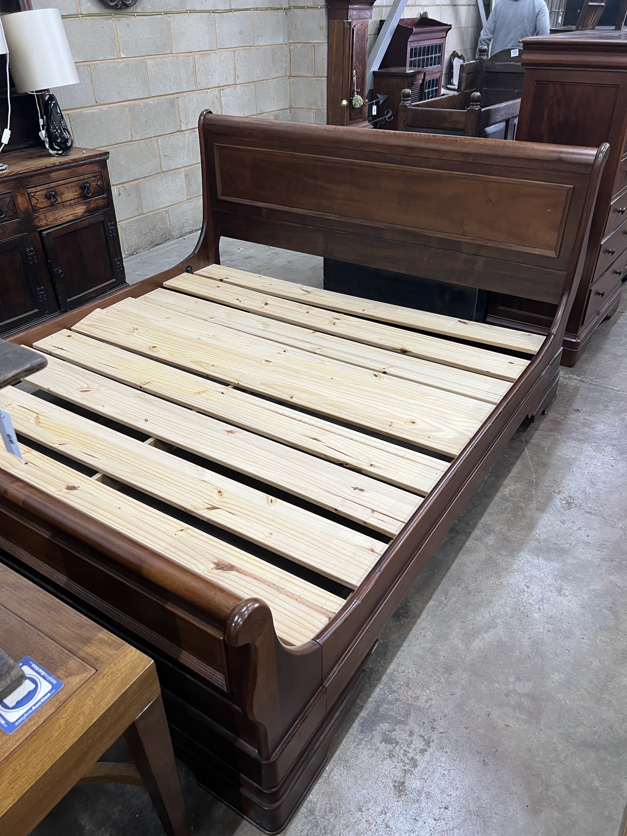 A contemporary five piece French mahogany bedroom suite, comprising sleigh bed, width 190cm, length 220cm, height 102cm (missing some bolts), a six drawer tall chest, three drawer chest and a pair of bedside chests